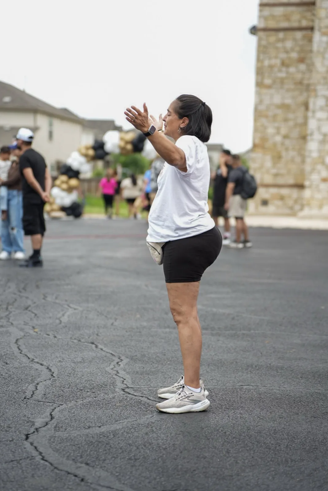 A woman raises her hands in worship at Holy City Market.