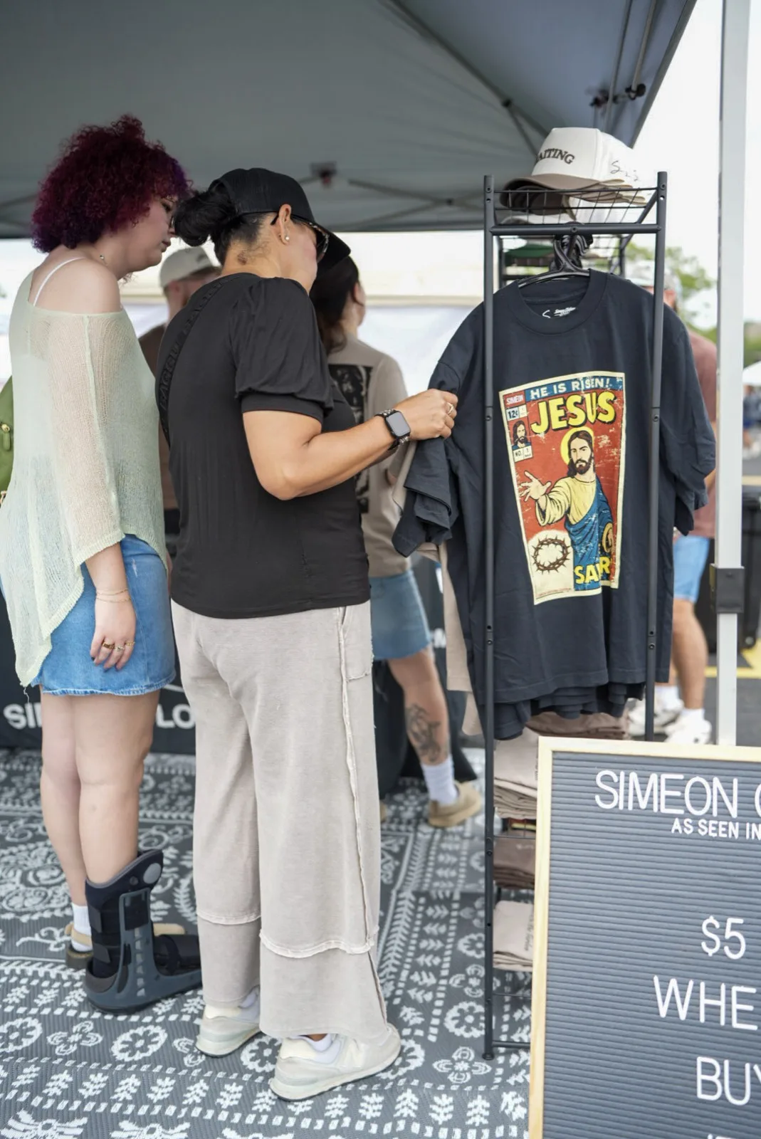 Attendees shopping for Christian apparel at a vendor booth at Holy City Market.