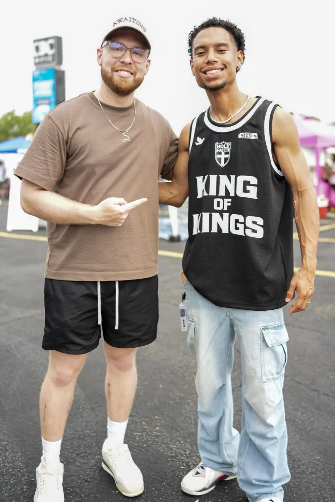 Two young men smiling at Holy City Market, one wearing a King of Kings jersey.